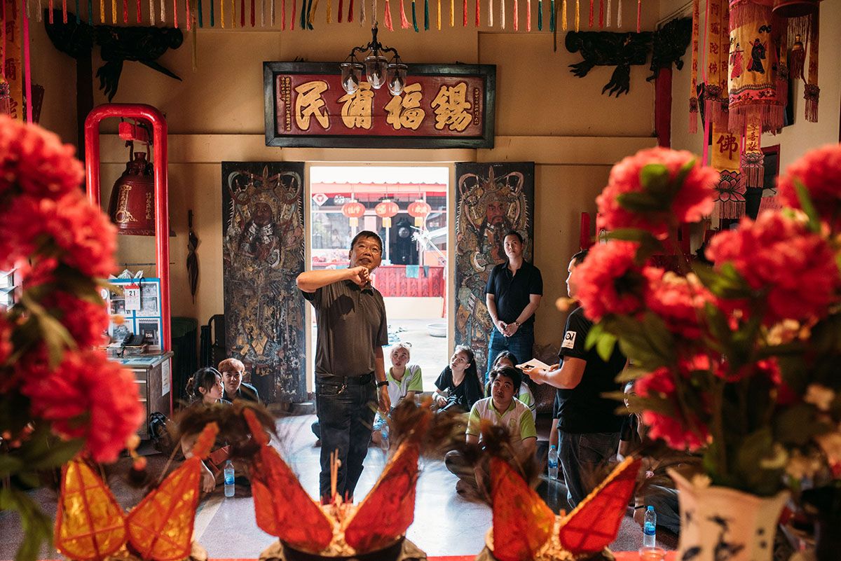 Tour guide showing the students the cultural meaning of a Chinese temple