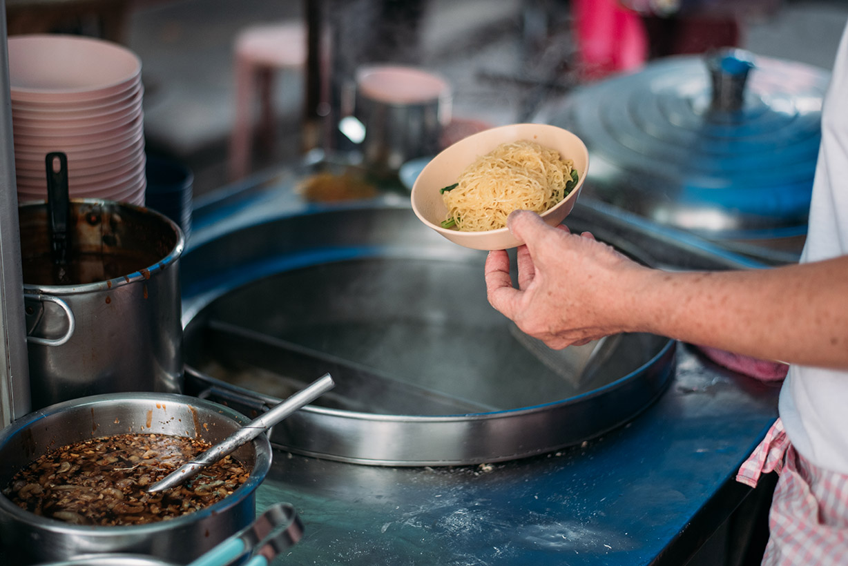 street vendors making noodles soup