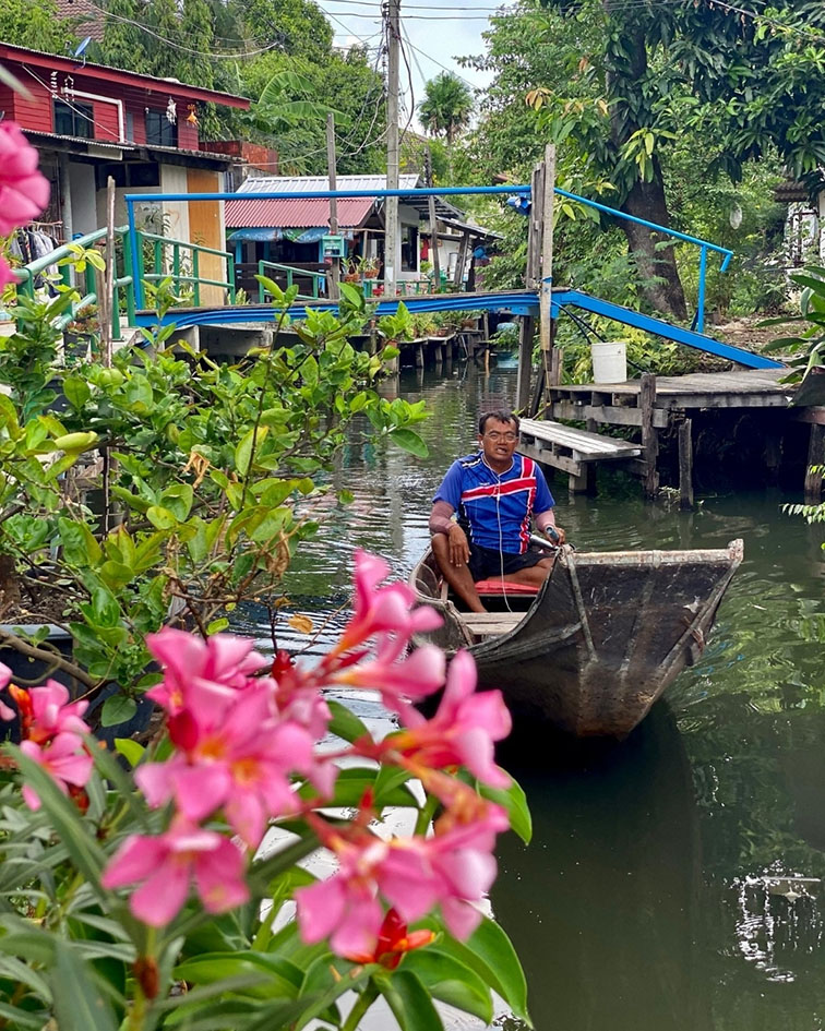 Man paddles a boat in the canal in Bangkok
